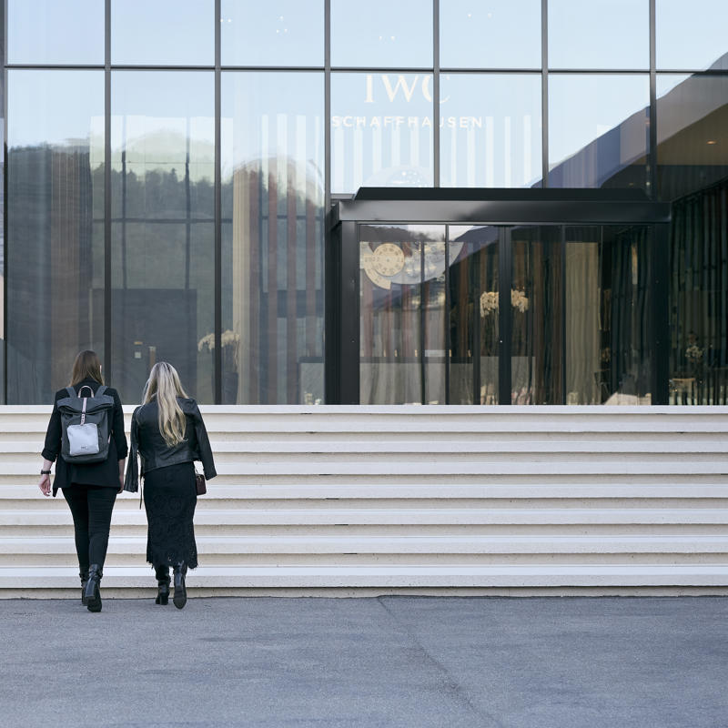 two women walking up stairs in front of a building