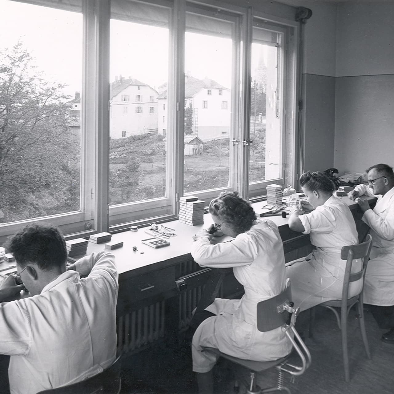 a group of people in white coats working in a laboratory