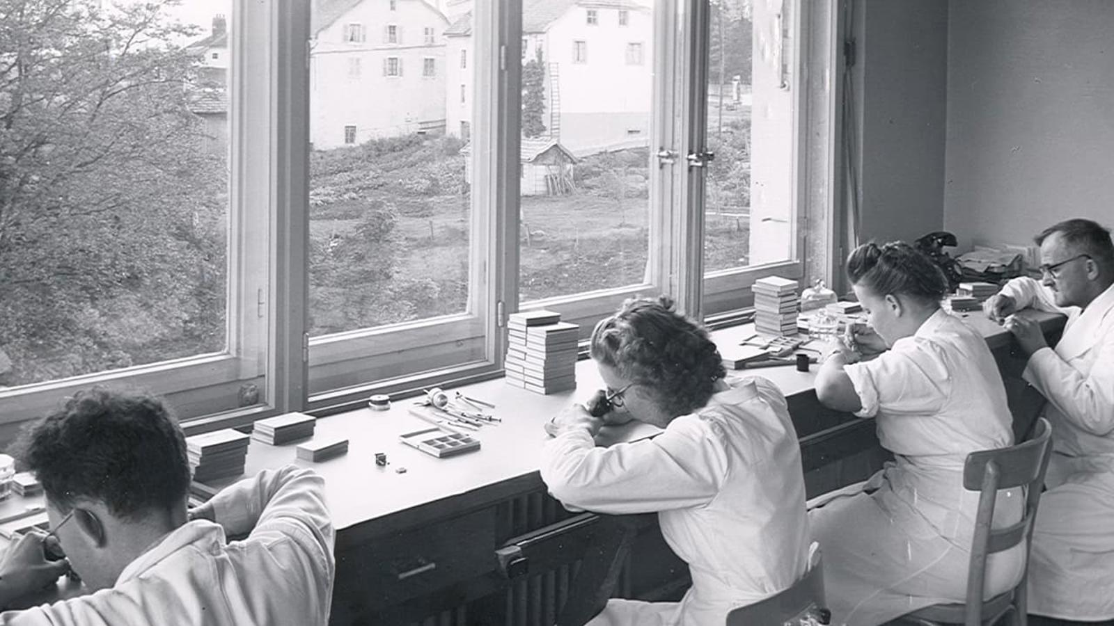 a group of people in white coats working in a laboratory