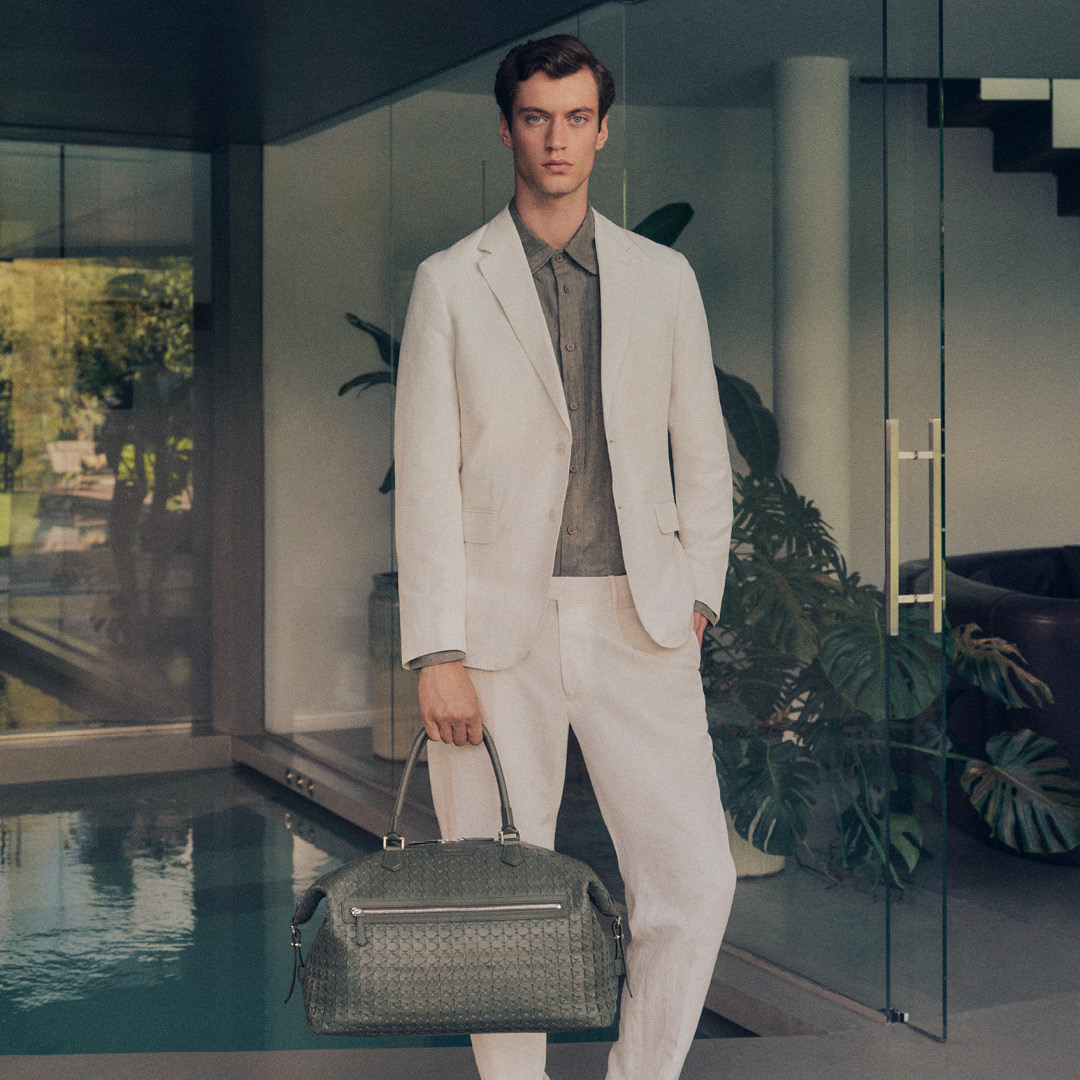 a person in a white suit holding a bag