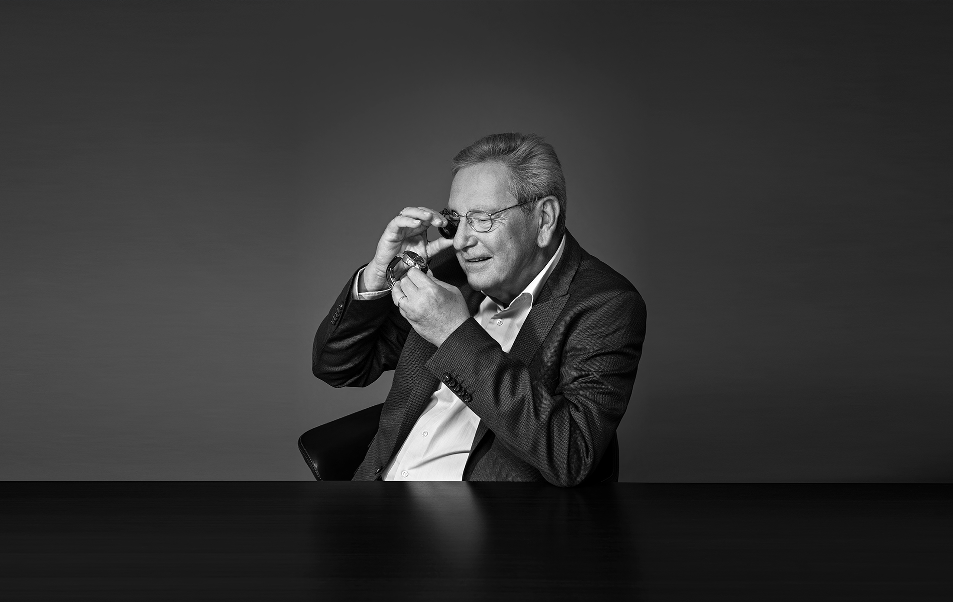 a person in a suit looking through a telescope