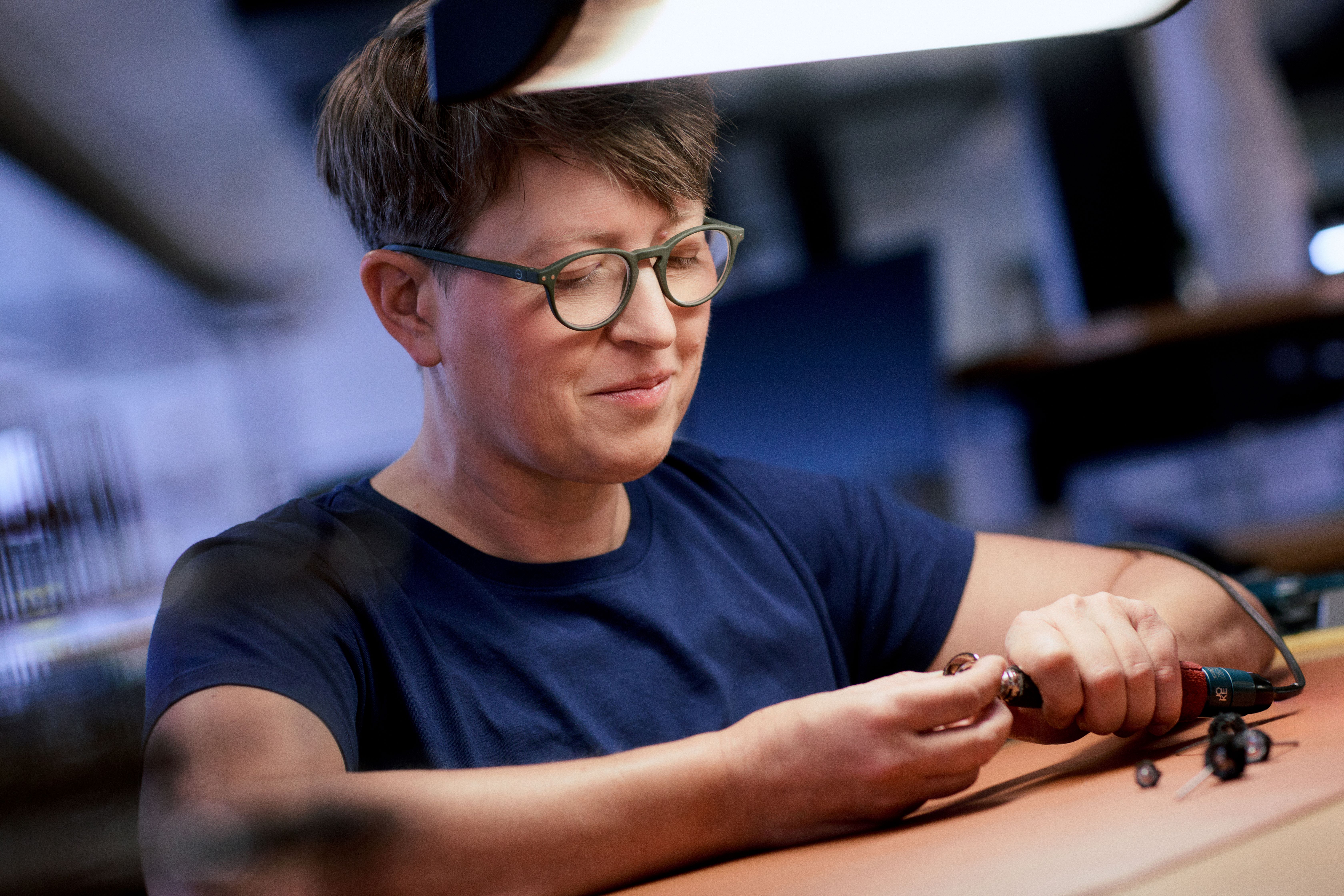 a person wearing glasses and looking down at a lamp