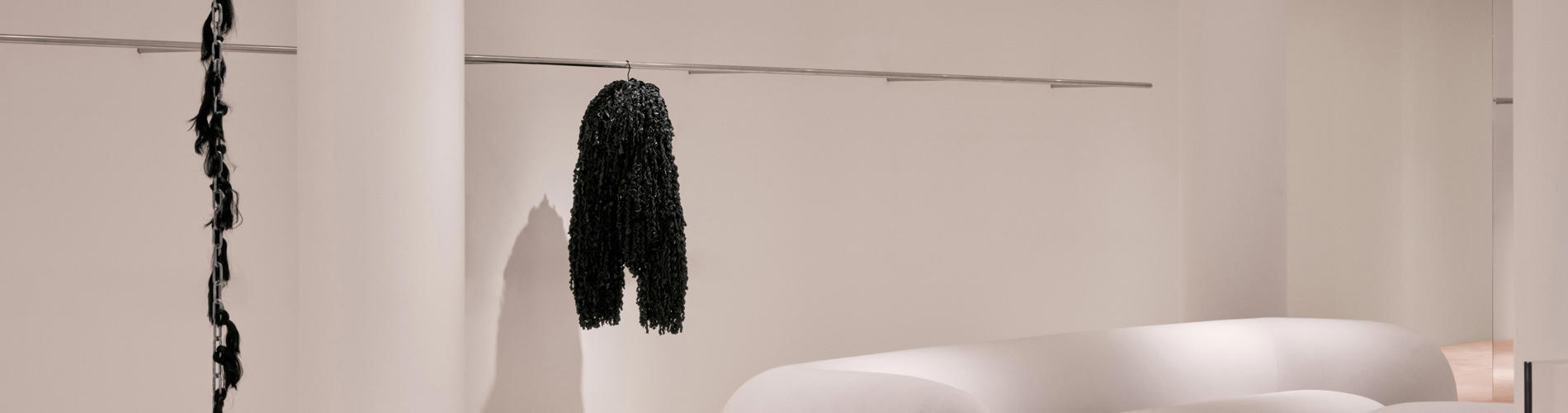 a room with white columns and a black scarf on a hook